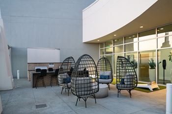 a seating area with chairs and a table in front of a building